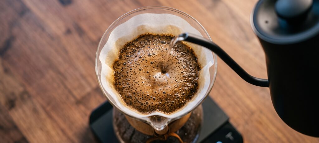 Pouring hot water over grounds to brew better coffee at home